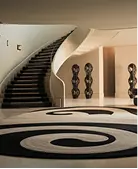 Villa entrance hall with curved staircase and custom rug, interior fit-out in Dubai